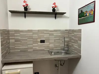a kitchen counter with a sink and a shelf at Cortili Himeresi in Termini Imerese