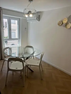 a dining room with a glass table and two chairs at Vivimi Deluxe Apartment in Palermo