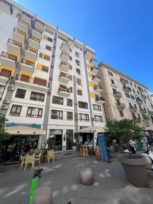 a large white building with tables and chairs in front of it at Vivimi Deluxe Apartment in Palermo