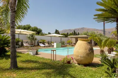 a pool with a large pot next to a resort at 14th Oasis Villa With Private Pool Near Palermo in Carini