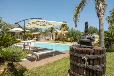 a house with a pool with a wooden barrel and a fountain at 14th Oasis Villa With Private Pool Near Palermo in Carini