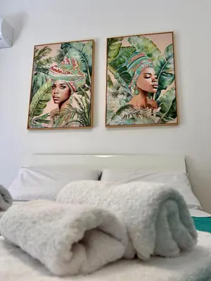 three paintings on the wall above a bed at Leonetti Due in Carini