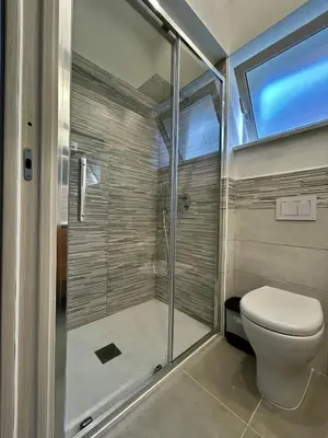 a bathroom with a toilet and a glass shower at Leonetti Due in Carini