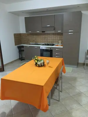 a kitchen with a table with an orange table cloth on it at Dall'Orso Grigio in Balestrate