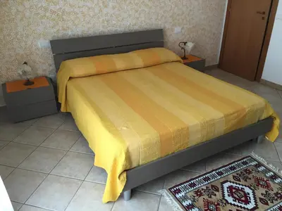 a bedroom with a bed with a yellow blanket on it at Dall'Orso Grigio in Balestrate