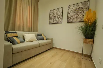 a living room with a couch and a plant at Beta Suite in Palermo