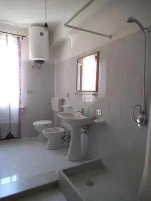 a white bathroom with a sink and a toilet at ClimaDerna SX Climatizzata in Castellammare del Golfo