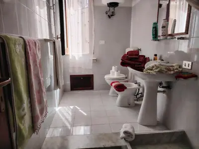 a white bathroom with a sink and a toilet at ClimaDerna SX Climatizzata in Castellammare del Golfo
