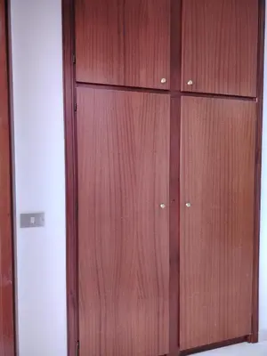 a wooden closet with two doors on a wall at ClimaDerna SX Climatizzata in Castellammare del Golfo