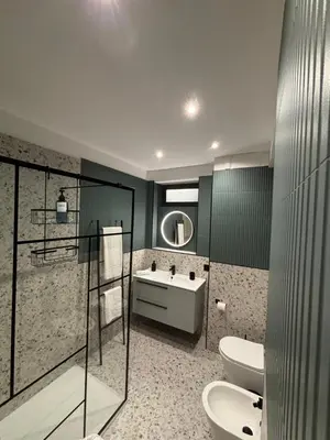 a bathroom with a shower with a glass door at Grand Holiday Home Namarì in Palermo