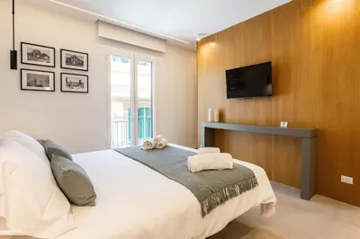 a bedroom with a large bed and a flat screen tv at Capo D'Amuri in Palermo