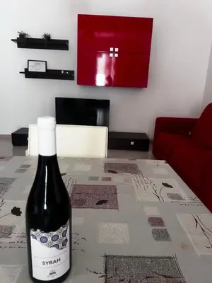 a bottle of wine sitting on a table in a living room at Casa Vacanze Fabrizio in Balestrate