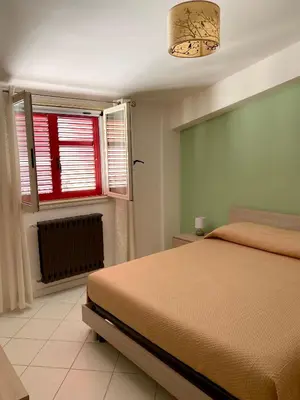 a bedroom with a bed and a window at Casetta in piazza in Palazzo Adriano