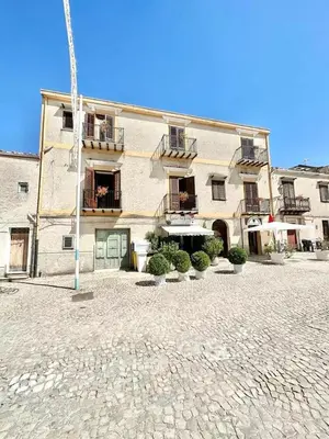 a large building with a courtyard in front of it at Casetta in piazza in Palazzo Adriano