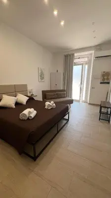 a large bedroom with a bed and a couch at Amuní Holiday House in Cinisi