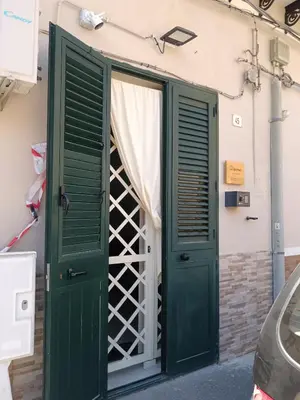 a door with green shutters on a building at La casa di Marió in Palermo