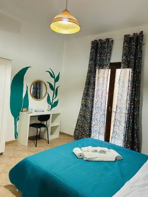 a bedroom with a blue bed with a desk and a mirror at Mercede rooms Ballaró in Palermo