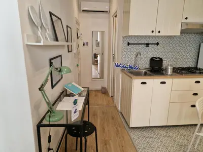 a kitchen with a desk with a lamp on it at Come a Casa by Holiday World in Palermo