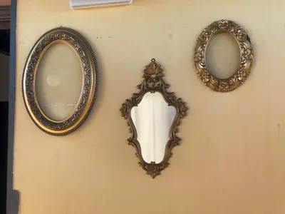 three mirrors are hanging on a wall at La casetta dei limoni in Santa Flavia