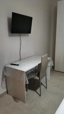 a desk with a chair and a television on a wall at Casa Verdi in Capaci
