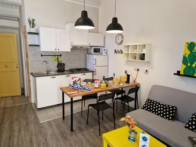 a kitchen and living room with a table and a couch at Il Fico d'India by Holiday World in Palermo