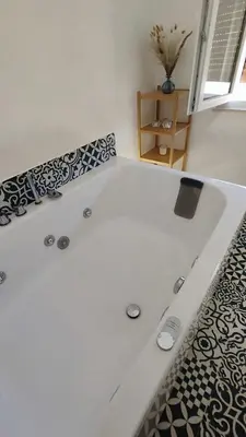 a white bath tub with a black and white tile at Disìu Apartment con Jacuzzi in centro a Castellammare del Golfo in Scopello