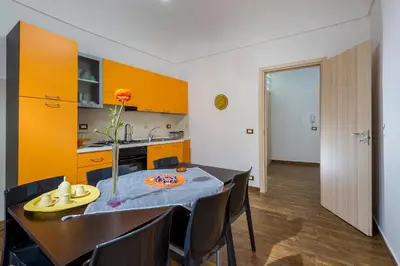 a kitchen and dining room with a table and yellow cabinets at Oasi del Libro in Castellammare del Golfo