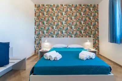 a bedroom with a blue bed with towels on it at Villa Giunella in San Vito lo Capo