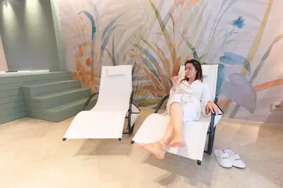 a woman sitting in a chair talking on a cell phone at Eccelso Case Vacanza in Palermo