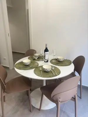 a white table with chairs and a bottle of wine at A due passi in Balestrate