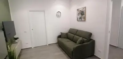 a living room with a couch and a clock on the wall at A due passi in Balestrate