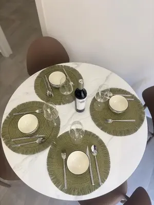 a white table with green plates and wine glasses at A due passi in Balestrate