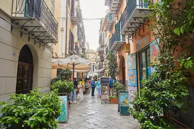 a narrow street with people walking down it at A 2 passi dal Teatro Massimo in Palermo