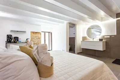 a white bedroom with a large bed and a sink at La Camera di Carolino in Palermo