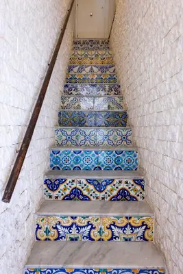 a staircase with blue and white tiles on the stairs at La Camera di Carolino in Palermo