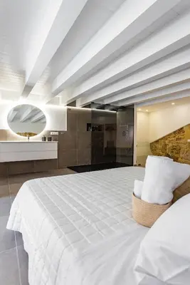a bedroom with a large white bed and a bathroom at La Camera di Carolino in Palermo