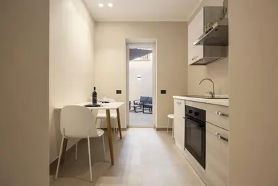 a kitchen with a table and chairs in a room at Lolli Boutique & SPA Mondello in Palermo