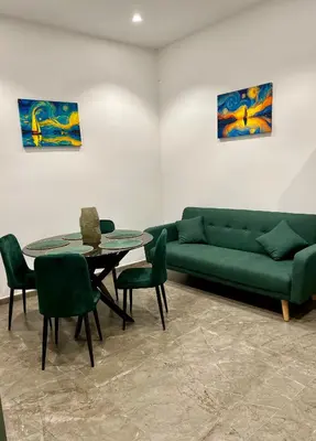 a living room with a green couch and a table at Fervore Luxury Rooms-Apartments in Palermo