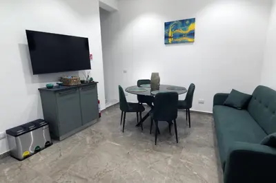 a living room with a couch and a table with chairs at Fervore Luxury Rooms-Apartments in Palermo