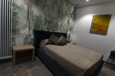 a small bedroom with a bed and a table at Fervore Luxury Rooms-Apartments in Palermo