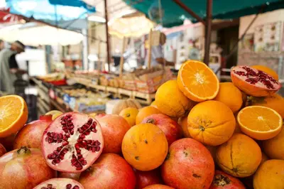 a pile of fruit in a market with oranges and apples at A casa di Maria in Palermo