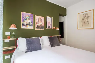 a bedroom with a white bed with pictures on the wall at Cassaro261 in Palermo