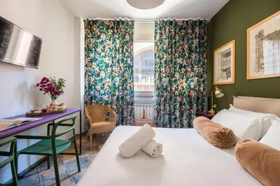 a hotel room with two beds and a desk at Cassaro261 in Palermo