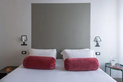two red pillows sitting on top of a bed at Cassaro261 in Palermo