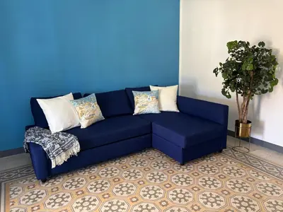a blue couch in a room with a blue wall at Le Lunette Holiday House in Palermo
