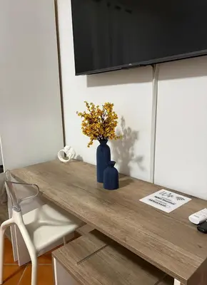 a blue vase with flowers on a wooden table at Casa Marì-Albergheria in Palermo's historic center in Palermo