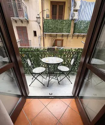 a patio with a table and chairs on a balcony at Casa Marì-Albergheria in Palermo's historic center in Palermo