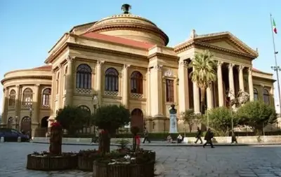a large building with people walking in front of it at La Suite nel Centro di Palermo in Palermo