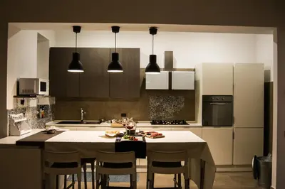 a kitchen with a table with chairs and a counter top at Home In City in Palermo
