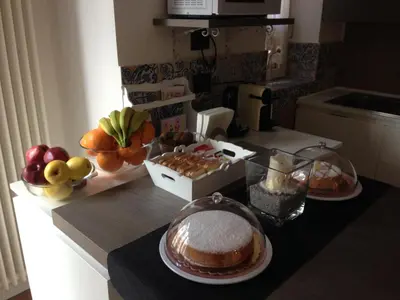a kitchen counter with a cake and fruit on it at Home In City in Palermo